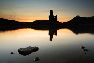 Sunset at Loch Assynt with the ruin of Ardvreck Castle and the Quinag mountain range reflecting on the calm water. <br /><a href="https://shop.photo4me.com/picture.aspx?id=277454&f=canvas"><font>Buy Print or Canvas</font></a><a></a> <a href="https://shop.photo4me.com/picture.aspx?id=277454&f=canvas"><img src="https://www.photoscotland.net/captionpic/p4me.jpg" alt="p4me.jpg" /></a><a></a><a></a> Buy License and Download from <a href="https://www.picfair.com/pics/ardvreck-castle-sunset"><font>Picfair</font></a><a></a>