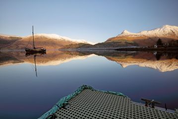 From a jetty on Loch Leven the snow covered pap of Glencoe (Sgorr na Ciche) and boat reflects on a perfectly calm Loch Leven.<br /><a href="https://shop.photo4me.com/547096/canvas"><font>Buy Print or Canvas</font></a><a></a> <a href="https://shop.photo4me.com/547096/canvas"><img src="https://www.photoscotland.net/captionpic/p4me.jpg" alt="p4me.jpg" /></a><a></a>