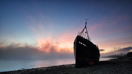 An abandoned boat lays on the shore of Coal beach while the Sun breaks through the mist creating a crimson glow in the sky at Sunset.<br /><a href="https://shop.photo4me.com/picture.aspx?id=630014&f=canvas"><font>Buy Print or Canvas</font></a><a></a> <a href="https://shop.photo4me.com/picture.aspx?id=630014&f=canvas"></a><a></a>