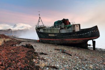 An abandoned boat lays on the shore of Coal beach while the mist clears revealing the snow covered Ben Nevis and colourful sky at Sunset.<br /><a href="https://shop.photo4me.com/picture.aspx?id=630000&f=canvas"><font>Buy Print or Canvas</font></a><a></a> <a href="https://shop.photo4me.com/picture.aspx?id=630000&f=canvas"></a><a></a>